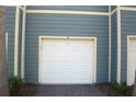 Attached one car garage with white door and blue siding at 5681 Bidwell Pkwy # 104, Sarasota, FL 34233