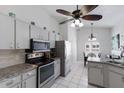 Bright eat-in kitchen featuring white cabinetry, stainless steel appliances, and tile flooring at 613 E 49Th E St, Bradenton, FL 34208