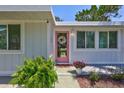 Inviting front entrance with a pink door, a decorative wreath, and lush ferns adding a touch of charm at 643 Calle Del Otono, Sarasota, FL 34242