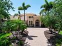 Elegant home with lush landscaping, a tile roof, and a circular driveway at 6808 Belmont Ct, Lakewood Ranch, FL 34202