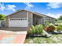Charming single-story home featuring stone accents, a two-car garage, and a well-manicured front yard at 7321 Caladesia Dr, Sarasota, FL 34243