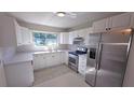 Modern kitchen with white cabinets, quartz countertops, and stainless steel appliances at 7524 Kavanda St, North Port, FL 34287