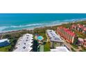 Overhead view of beachfront condos, pool, shuffleboard court, and ocean access at 8779 Midnight Pass Rd # 506H, Sarasota, FL 34242