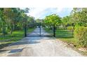 Gated entry to a long driveway leading to the house, ensuring privacy at 950 Trotter St, Nokomis, FL 34275