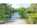 View of the long driveway, starting from a decorative gate and leading to the residence at 950 Trotter St, Nokomis, FL 34275
