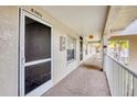 Exterior condo hallway featuring a secured entrance, carpeted floors, and a view of palm trees at 9630 Club South Cir # 6303, Sarasota, FL 34238