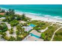 Aerial view highlights a property's pool, lush surroundings, and proximity to the beach at 102 77Th St, Holmes Beach, FL 34217