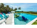 Relaxing pool area with in-pool seating and colorful Adirondack chairs, perfect for enjoying the sun at 102 77Th St, Holmes Beach, FL 34217