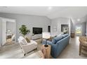 Cozy living room features neutral tones, stylish furniture, a vaulted ceiling, and an open layout at 10547 Kidron Ave, Englewood, FL 34224