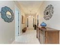 Elegant hallway featuring light wood floors, decorative mirror and sconces at 12175 Maple Ridge Dr, Parrish, FL 34219