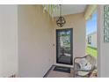 Inviting front porch with a decorative light fixture, welcome mat, and comfortable seating at 12322 Tall Pines Way, Lakewood Ranch, FL 34202