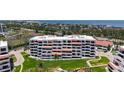 Multi-story condo building featuring private balconies with shaded awnings and manicured green spaces at 1465 Gulf Of Mexico Dr # 502, Longboat Key, FL 34228