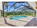View of the screened in pool and jacuzzi with brick tiling and outdoor view at 15006 21St E Ave, Bradenton, FL 34212
