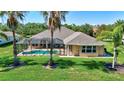 Home exterior featuring a screened in pool area, with manicured lawn, and palm trees at 15006 21St E Ave, Bradenton, FL 34212
