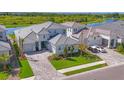 Aerial view of the home showcasing the meticulously landscaped yard, lake view, and three-car garage at 17122 Ranchside Pl, Bradenton, FL 34211