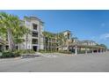 Three-story condominium building with covered parking, lush landscaping, and handicap parking at 17704 Gawthrop Dr # 303, Lakewood Ranch, FL 34211