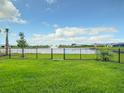 Fenced backyard offers a view of the water feature in the community at 18510 Midsummer Pl, Venice, FL 34293