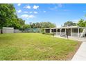 Expansive backyard features a well-maintained lawn, screened in back porch, and plenty of green space at 2015 Bayshore Gardens Pkwy, Bradenton, FL 34207
