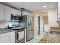 Modern kitchen boasts stainless steel appliances, granite countertops, and white cabinetry at 2015 Bayshore Gardens Pkwy, Bradenton, FL 34207