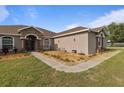 Landscaped front yard with a small seating area and walkway leading to the front door at 2350 Virgil Hall Rd, Lithia, FL 33547