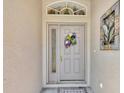 Close-up of the front door featuring decorative wreath and sidelight at 24512 Bramhope Ct, Punta Gorda, FL 33980