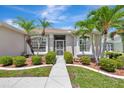 Inviting front entrance with lush landscaping and manicured bushes and palm trees at 24512 Bramhope Ct, Punta Gorda, FL 33980