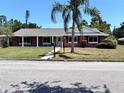 Inviting one-story brick home featuring a covered entryway and a lush green lawn at 2720 12Th Ave W, Bradenton, FL 34205