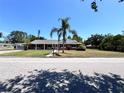 Charming one-story brick home featuring a well-manicured lawn and a mature palm tree in the front yard at 2720 12Th Ave W, Bradenton, FL 34205