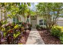 Inviting front entrance with mature landscaping and walkway at 2816 Breton Woods, Sarasota, FL 34235