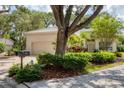 Charming home featuring a tile roof, neutral exterior paint, mature landscaping, and a spacious driveway at 2816 Breton Woods, Sarasota, FL 34235