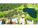 An aerial view of house with screened pool enclosure and a golf course and pond in the background at 2901 Little Country Rd, Parrish, FL 34219