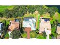 Aerial view of beautiful home, lush landscaping, screened-in pool, and brick paver driveway surrounded by mature trees at 2901 Little Country Rd, Parrish, FL 34219