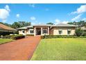 Inviting home exterior boasts a tiled roof, covered entryway, immaculate landscaping, and a brick paved drive at 2901 Little Country Rd, Parrish, FL 34219