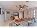 Spacious living room featuring a plush sectional sofa, decorative ceiling fan and a wall-mounted television at 3417 49Th W St, Bradenton, FL 34209