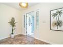 Bright entryway featuring tile flooring and a decorative glass door leading to a naturally-lit front porch at 3585 Brooklyn Ave, Port Charlotte, FL 33952