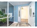 Inviting front porch with a tiled floor, screened walls and an open door, showing natural light at 3585 Brooklyn Ave, Port Charlotte, FL 33952
