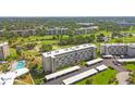 Attractive aerial view of the condo complex, highlighting the pool, parking and lush golf course at 3820 Ironwood Ln # 104-I, Bradenton, FL 34209