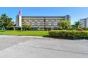 Well-maintained condo building exterior with covered parking, manicured landscaping, and American flag at 3820 Ironwood Ln # 104-I, Bradenton, FL 34209