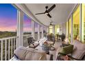 A spacious, covered balcony featuring comfortable seating and stunning views of the surrounding landscape and water at 401 N Point Rd # 504, Osprey, FL 34229