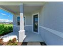 Cozy front porch featuring a support column, a view of the neighborhood, and a stylish front door at 4210 Sea Marsh Pl, Parrish, FL 34219