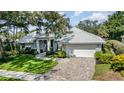 Charming home features a tile roof, manicured lawn and a brick paver walkway to the front door at 4374 Indian Point Trl, Sarasota, FL 34238