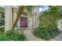 Elegant entryway showcases a striking purple door framed by decorative columns and lush landscaping at 5044 Creekside Trl, Sarasota, FL 34243