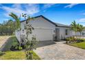 Beautiful one-story home featuring a well-manicured lawn, brick driveway, and attached two-car garage at 5213 Patano Loop, Palmetto, FL 34221