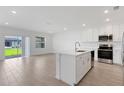 Open-concept kitchen featuring white cabinets, stainless steel appliances, and a center island perfect for entertaining at 5213 Patano Loop, Palmetto, FL 34221
