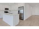 Well-appointed kitchen with white cabinetry, stainless steel refrigerator, and a central island with marble countertop at 5213 Patano Loop, Palmetto, FL 34221