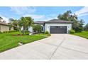 Beautiful one-story home with a wide driveway, manicured lawn, and tropical landscaping at 5285 Far Oak Cir, Sarasota, FL 34238