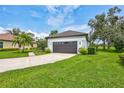 Well-maintained home with a spacious driveway and lush, green lawn surrounded by trees at 5285 Far Oak Cir, Sarasota, FL 34238
