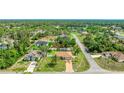 Aerial view of a cozy home nestled among lush greenery and mature trees in a quiet neighborhood at 5307 Kenvil Dr, North Port, FL 34288