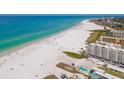 Aerial view of a condo on a pristine beachfront offering a pool, lounging areas, and clear blue waters at 5880 Midnight Pass Rd # 207, Sarasota, FL 34242