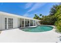 Inviting pool area with covered patio, outdoor dining space, and serene views of the landscaped yard at 6203 11Th W Ave, Bradenton, FL 34209